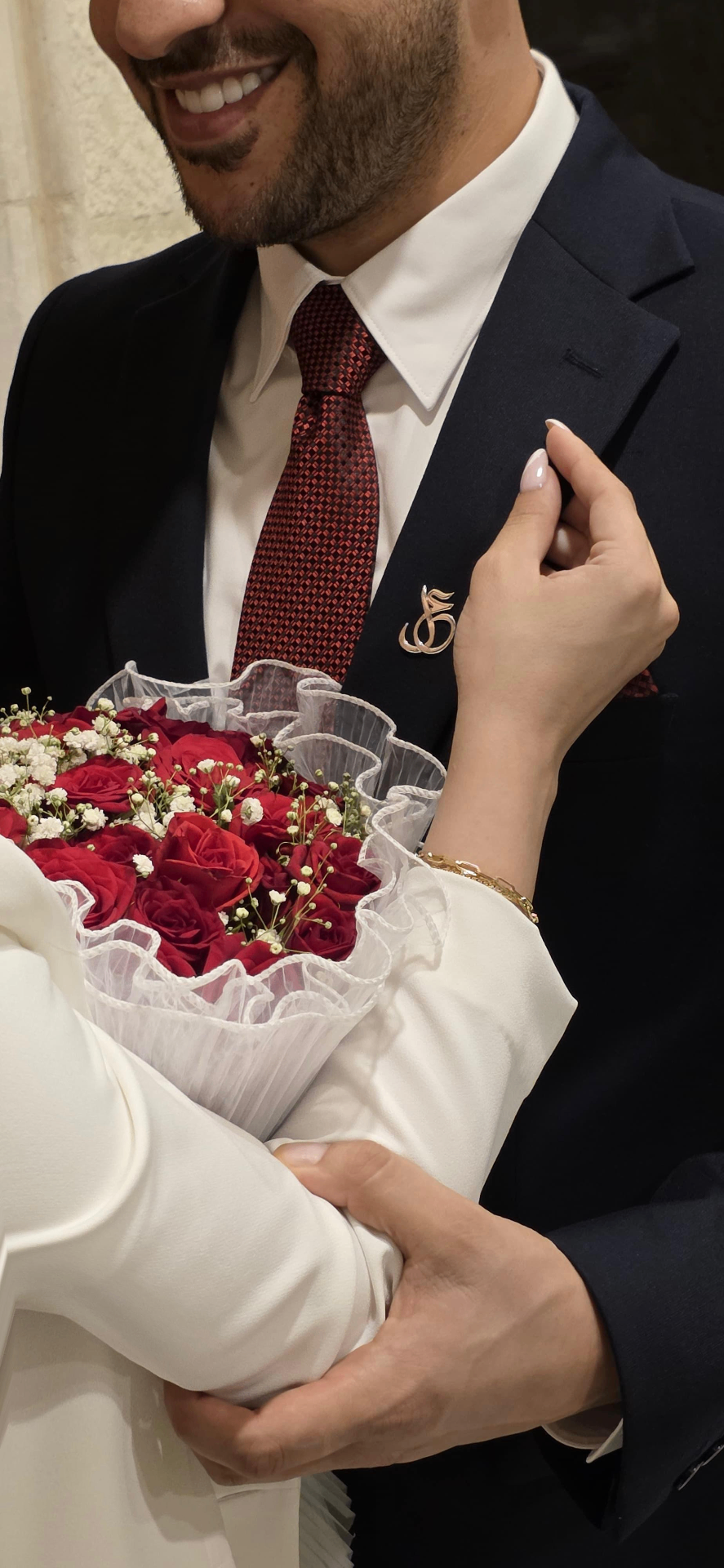 Amr and Lana on their engagement day, holding a bouquet of red roses